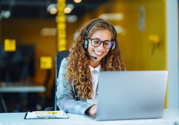 Call center agent with headset working on support hotline in modern office. Video conference.  Оnline training.